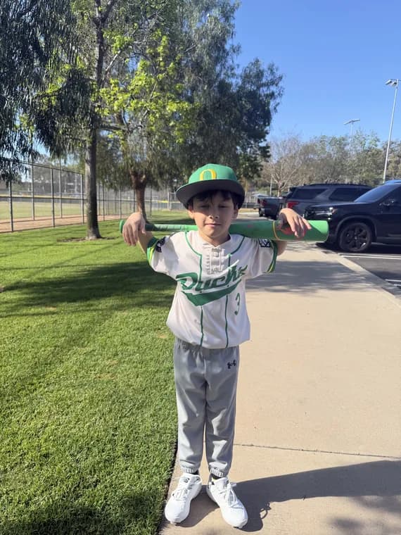 My son in his Rush uniform, bat across his shoulders, ready to go.